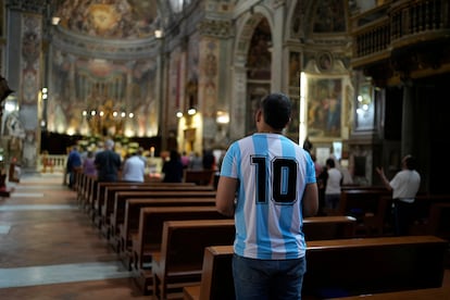 Un hombre con la camiseta argentina reza en la iglesia Santo Spirito in Sassia, Santuario de la Divina Misericordia, en Roma.