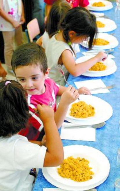 Un grupo de niños en un comedor escolar.