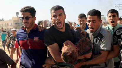Un palestino lleva a un hombre herido tras un ataque israelí en Rafah, en el sur de la franja de Gaza.