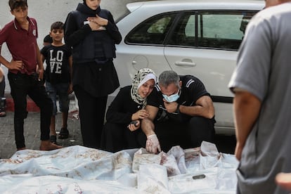 Una mujer y un hombre lloraban junto a los cuerpos de víctimas palestinas fallecidas durante los ataques israelíes, frente a la morgue del hospital Al Shifa, en Gaza.