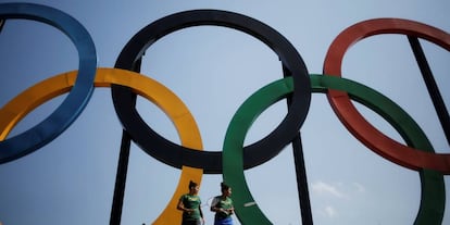 Dos jugadoras de bádminton, frente a un logo de los Juegos Olímpicos en Rio de Janeiro (Brasil), donde se celebrarán las Olimpiadas de este año.