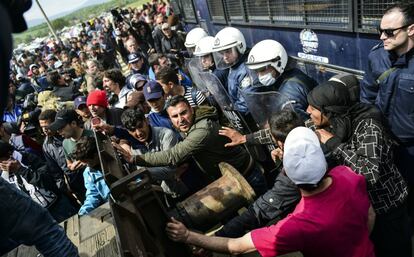 Un grupo de refugiados intenta pasar por una barricada controlada por la policía griega. Los migrantes piden la reapertura de la frontera cerca del campamento de Idomeni, en Grecia.