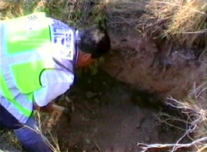 Un agente observa el agujero en el que la joven pasó tres días secuestrada.