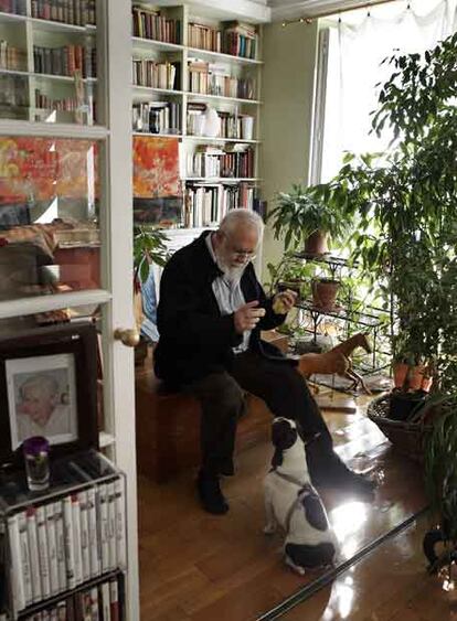 Gonzalo Suárez tienta con una uva a su perra <i>Margot</i> en el salón de su céntrica casa madrileña.