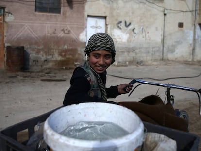 Un ni&ntilde;o transporta el agua en una barrio de Damasco, este febrero.
 