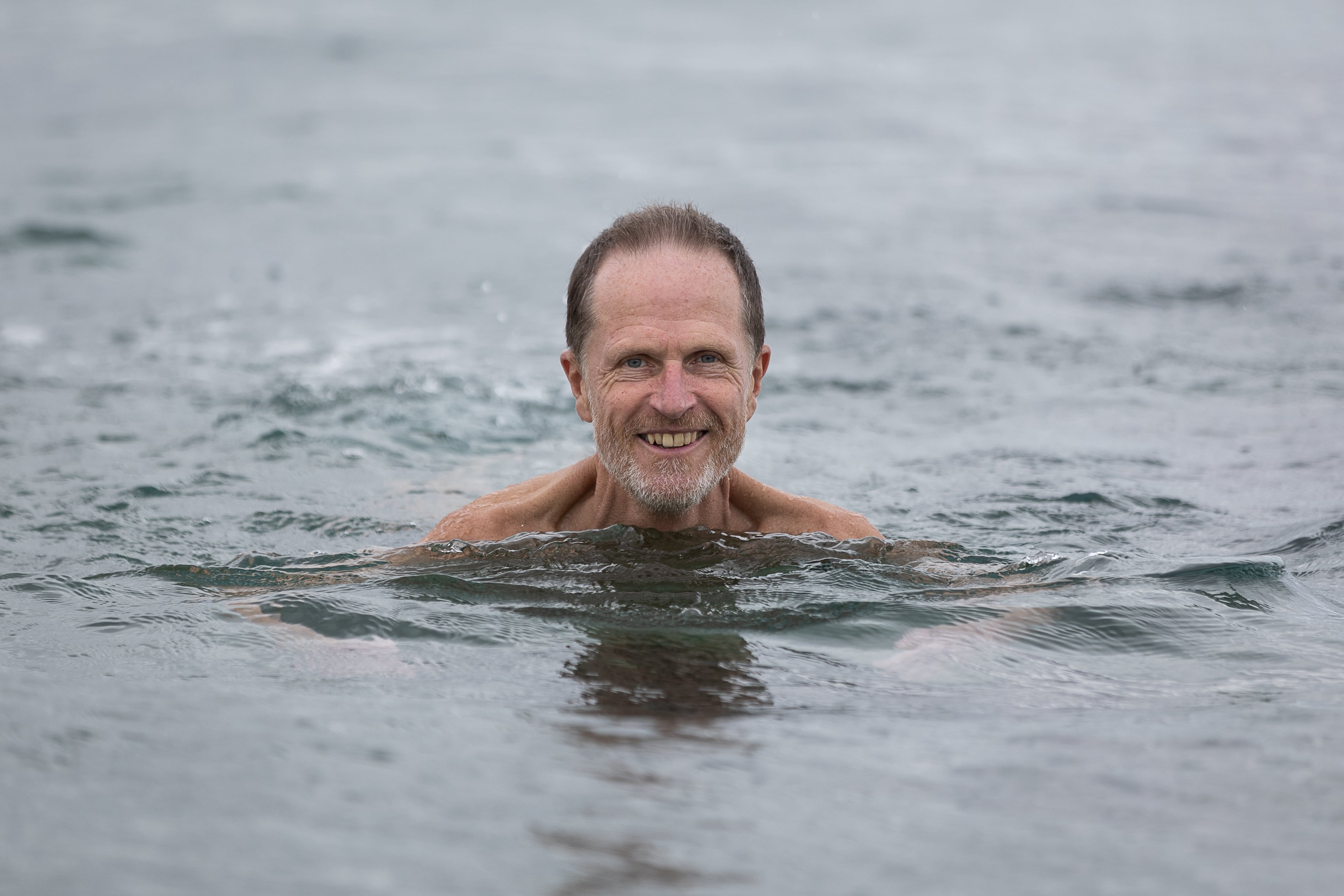 El escritor Philip Hoare, dentro del agua en la playa de la Nova Mar Bella, en Barcelona.