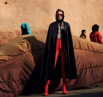 Capa con efecto charol y pantalones de neopreno, ambos de Balenciaga; 
camisa estampada 
de Isabel Marant y 
gafas de sol de Miu Miu.