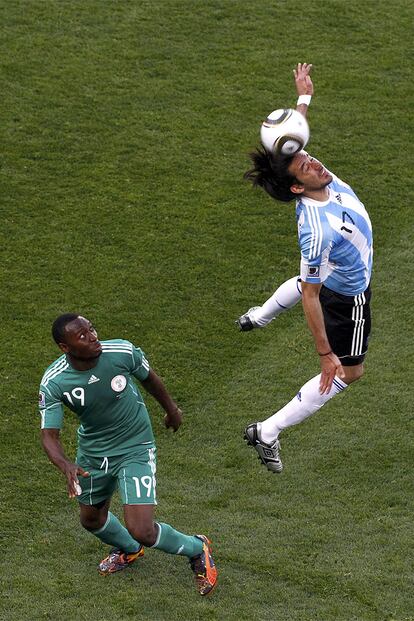 El lateral argentino cabecea el balón ante la atenta mirada de Obasi.