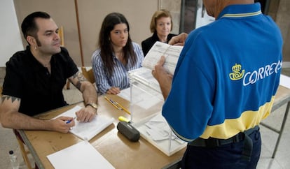 Un funcionario entrega en una mesa electoral de Girona los votos por correo.