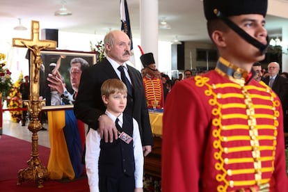 El presidente de Bielorusia Alexander Lukashenko y su hijo Nikolai junto al féretro de Chávez.