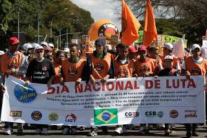 Un grupo de manifestantes sostienen un cartel durante una nueva jornada de protestas en Brasilia (Brasil).