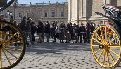 Un grupo de turistas hace cola en el centro de Sevilla.