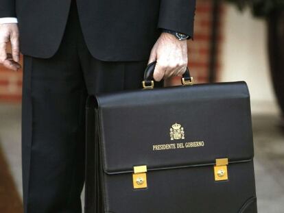 El presidente del Gobierno, Mariano Rajoy, llega al Palacio de la Moncloa con su cartera, tras jurar su cargo ante el rey en la Zarzuela.