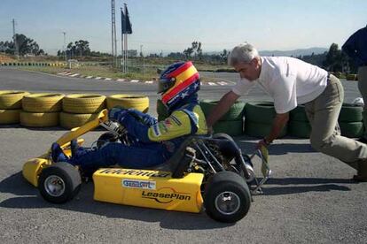 El padre de Alonso, Jos Luis, empuja el <i>kart</i> de su hijo en una pista de Oviedo.