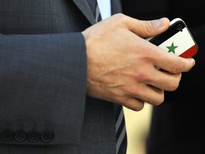 Un delegado sirio sostiene un teléfono con una carcasa con su bandera durante una sesión del Consejo de Derechos Humanos de la ONU.