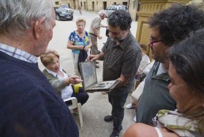 El fotógrafo examina álbumes familiares de los vecinos.