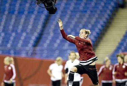 A alemã Simone Laudehr tenta dar um tapa em uma spidercam em um treinamento antes da semifinal da Copa do Mundo feminina do Canadá, em 2015. A spidercam é uma câmera zênite, sustentada a quase 20 metros de altura por cabos ancorados nos quatro cantos do estádio, que oferece planos aéreos muito cinematográficos graças aos quais pode girar em 360º e inclinar-se em 180º.