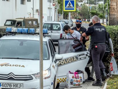 Agentes de la Policía Local de Ceuta introducen a dos inmigrantes en un coche, este miércoles.