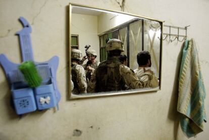Soldados de la brigada Stryker del Ejército estadounidense, reflejados en el espejo de una vivienda que inspeccionan a la búsqueda de insurgentes en Mosul, en julio de 2005.