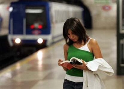 Una joven lee un libro sobre la Guerra Civil española en un andén de la estación de metro de Suanzes.