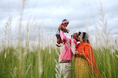 Unos padres juegan con sus hijos mientras visitan un campo en Diabari, en las afueras de Dacca, capital de Bangladés.