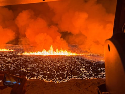 Emergency personell and scientists observe the billowing smoke and flowing lava turning the sky orange are seen in this Icelandic Coast Guard handout image flying over an volcanic eruption on the Reykjanes peninsula 3 km north of Grindavik, western Iceland on December 18, 2023. A volcanic eruption began on Monday night in Iceland, south of the capital Reykjavik, following an earthquake swarm, Iceland's Meteorological Office reported. (Photo by Icelandic Coast Guard / HANDOUT / AFP) / RESTRICTED TO EDITORIAL USE - MANDATORY CREDIT "AFP PHOTO /   " - NO MARKETING NO ADVERTISING CAMPAIGNS - DISTRIBUTED AS A SERVICE TO CLIENTS