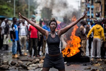 Una mujer, seguidora del partido de la oposición, protesta junto a una barricada que bloquea una carretera en el barrio de Mathare, en Nairobi.