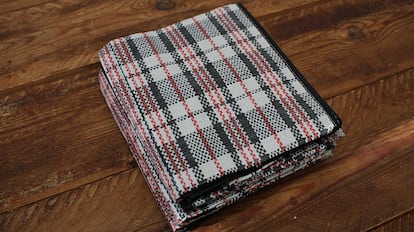 Bolsas de plástico para guardar ropa sobre una mesa de madera.