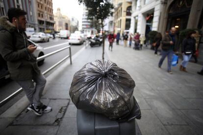 Una bolsa de basura en una papelera de la Gran Vía.