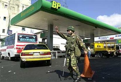 Un militar venezolano dirige el tráfico a la entrada de una gasolinera en Caracas.