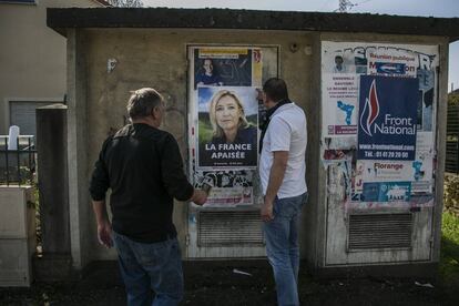 Grupo de militantes da Frente Nacional colam cartazes eleitorais em Hayange.