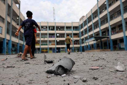 Niños gazatíes caminan en el patio de un colegio de la ONU, convertido en refugio para civiles, tras el bombardeo por parte de Israel el pasado 9 de octubre. 