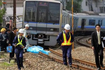 Empleados de la compañía ferroviaria inspeccionan el lugar del accidente.