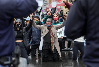 Unas mujeres protestan detrás de un cordón policial contra la violencia de género en una manifestación en Ciudad del Cabo, Sudáfrica, en 2020.