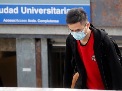 Un joven con mascarilla en el acceso a la estación de metro de Ciudad Universitaria, en Madrid.