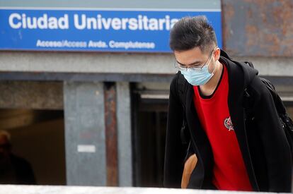 Un joven con mascarilla en el acceso a la estación de metro de Ciudad Universitaria, en Madrid.