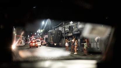 Jóvenes esperan a que se detenga un auto, en el barrio San Diego de Medellín.