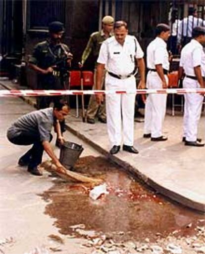 Un trabajador limpia el lugar del atentado en Calcuta.