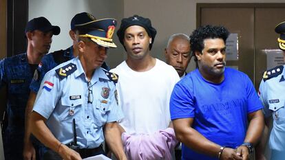 Ronaldinho aparece algemado ao lado do irmão ao chegar no Palácio da Justiça de Assunção, neste sábado.