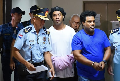 Ronaldinho aparece algemado ao lado do irmão ao chegar no Palácio da Justiça de Assunção, neste sábado.