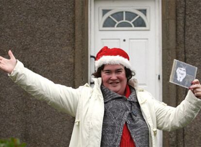 La escocesa Susan Boyle, frente a su casa y con su álbum en la mano.