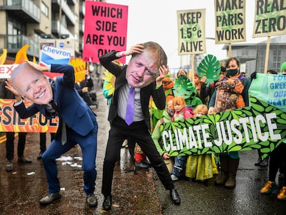 Activistas con máscaras de Joe Biden (izquierda) y Boris Johnson protestan a la entrada de la cumbre del clima, este viernes en Glasgow (Escocia).