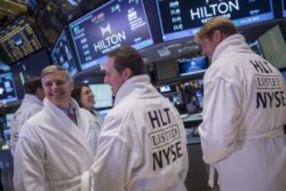 Directivos de Hilton posan en albornoz en el parqu&eacute; de Wall Street en el estreno en Bolsa de la cadena hotelera.