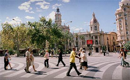 Paseantes por la plaza del Ayuntamiento de Valencia, libre de coches en la jornada de ayer.