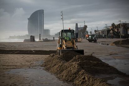 Una màquina apila la sorra a la plaça del Mar de Barcelona, de fons l'hotel W (hotel Vela).