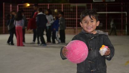 Un niño sostiene un balón en una noche de la Brigada de la Alegría en Nueva Galeana, un barrio de Juárez.