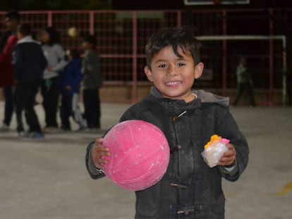 Un niño sostiene un balón en una noche de la Brigada de la Alegría en Nueva Galeana, un barrio de Juárez.