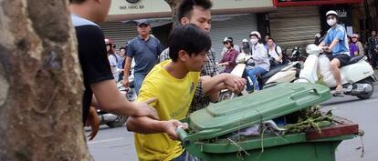 Dos policías de paisano detienen a un manifestante antichino en Hanoi el domingo.