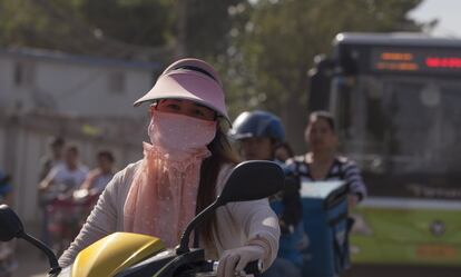 Una muestra fotográfica sobre la contaminación en los dos países más poblados del mundo, Chine e India, se exhibe en la Conferencia Mundial de La Unión sobre Salud Pulmonar en Liverpool para alertar sobre los efectos nocivos que causa la polución. En la imagen, una mujer se protege con una máscara para no respirar el aire contaminado de Pekín en China. El país asiático es uno de los que registran mayores problemas de agua contaminada y franjas de tierra infestadas de basura.