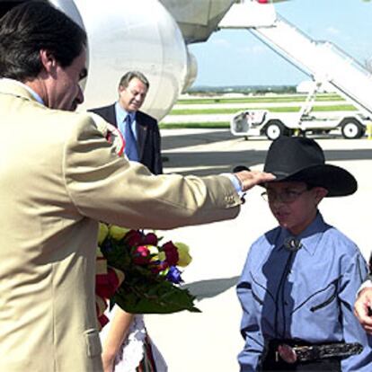Aznar saluda a un niño con sombrero tejano a la llegada al aeropuerto de San Antonio (Texas).